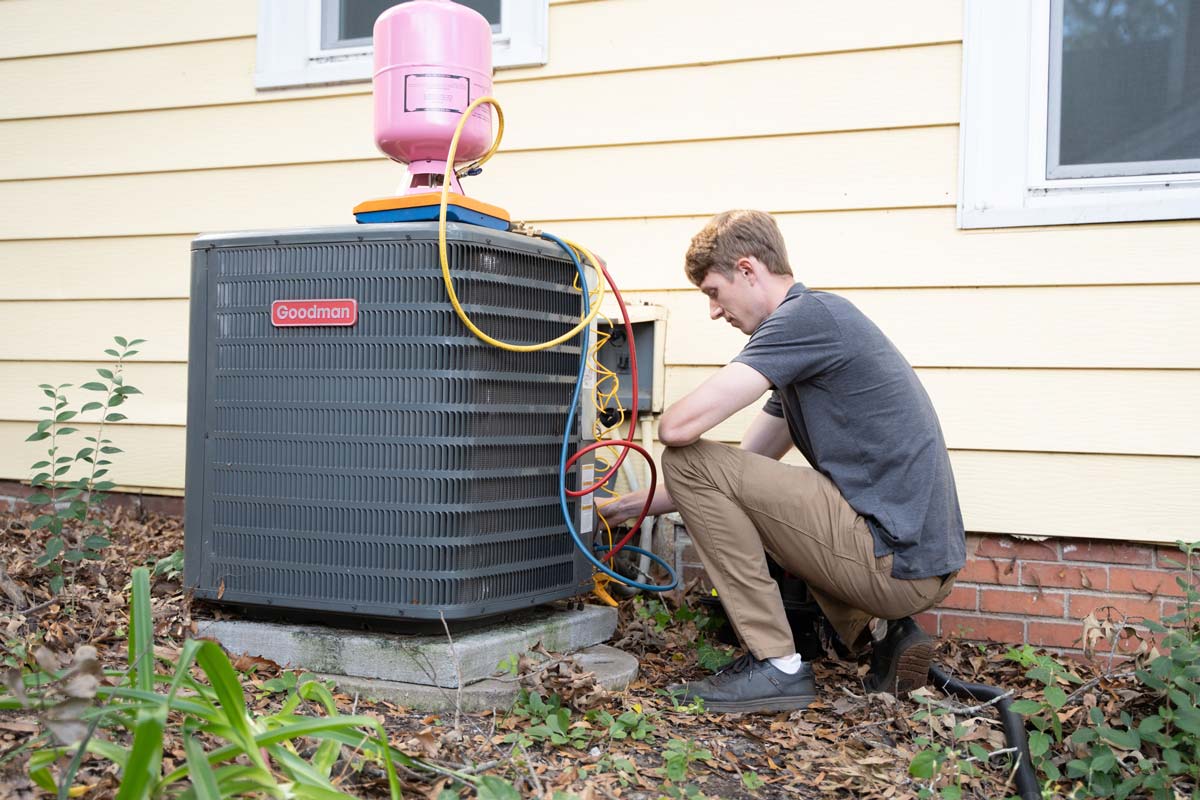 Heating, ventilation, and air conditioning professional repairing unit outside