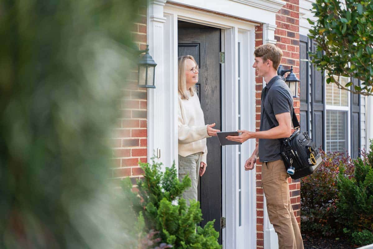 Heating, ventilation, and air conditioning professional checking in with customer