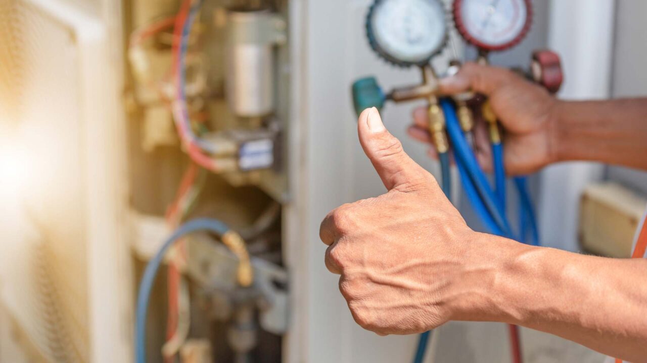 someone installing an HVAC system while giving a thumbs up