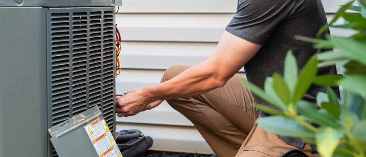 Technician servicing HVAC unit to help manage allergies during pollen season in your upstate home.